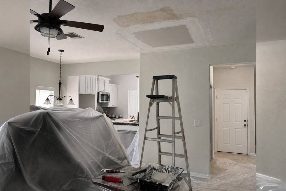 Ceiling drywall opened below a water stain during repair in a Brevard County home